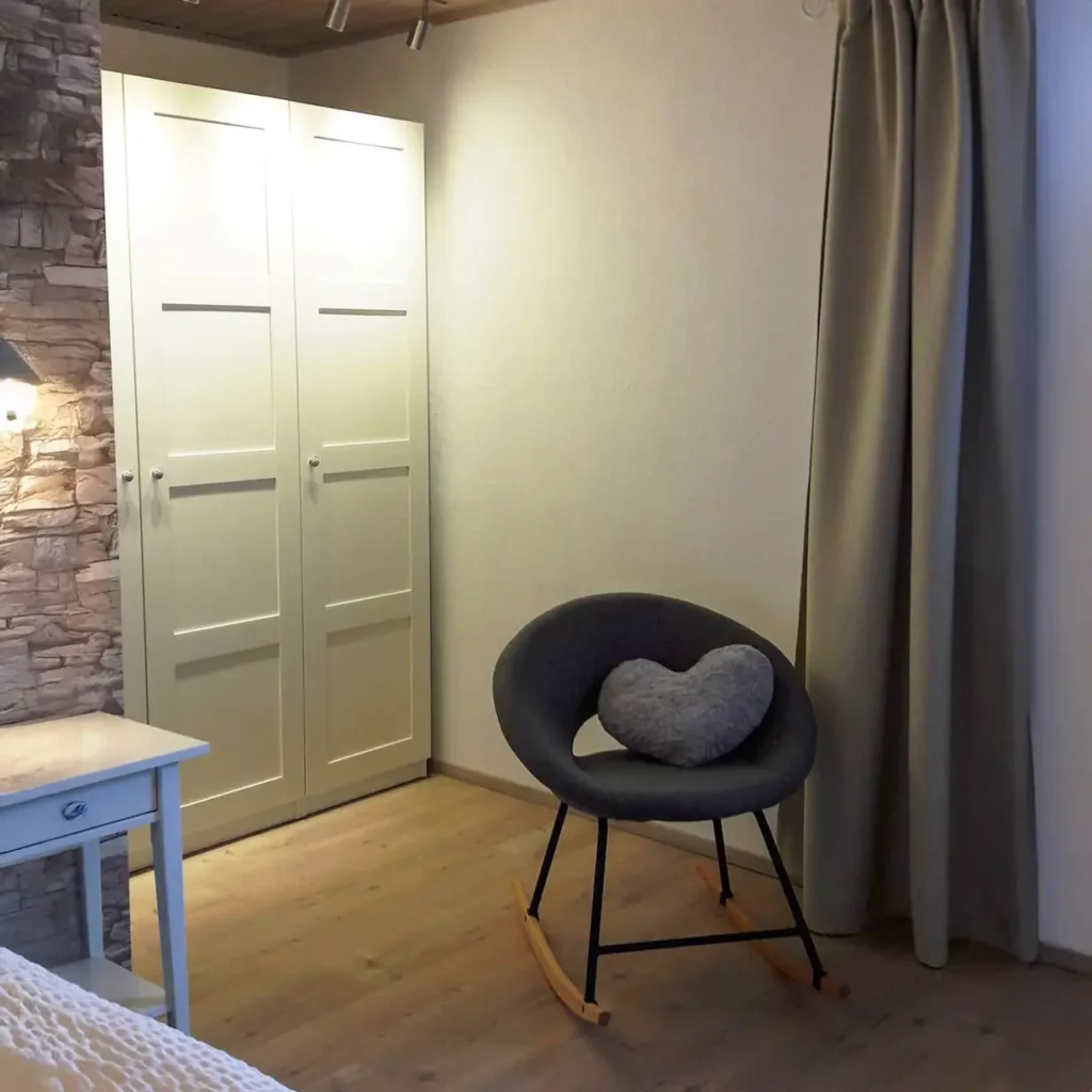 Kleiderschrank im Schlafzimmer mit davorstehenden Schaukelstuhl