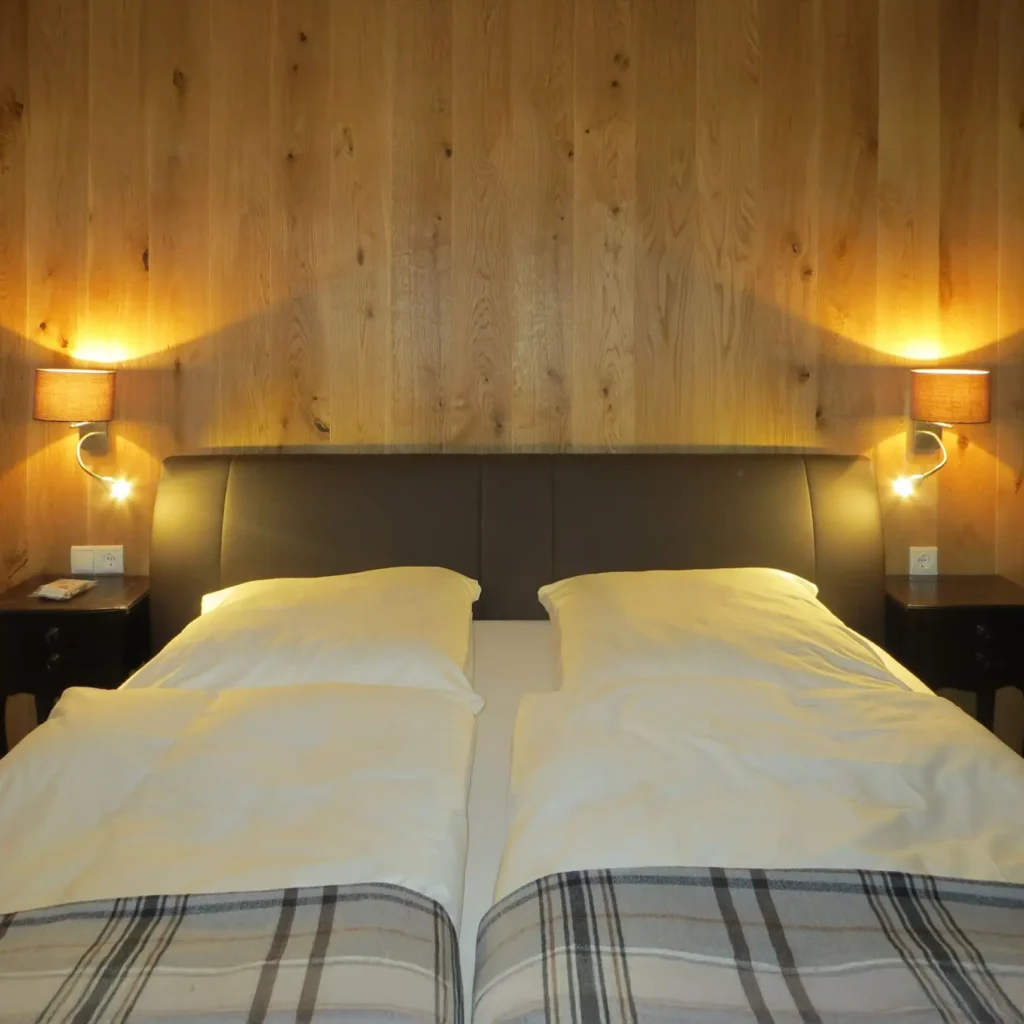 Modernes Boxspringbett mit eingeschalteter Beleuchtung im Schlafzimmer