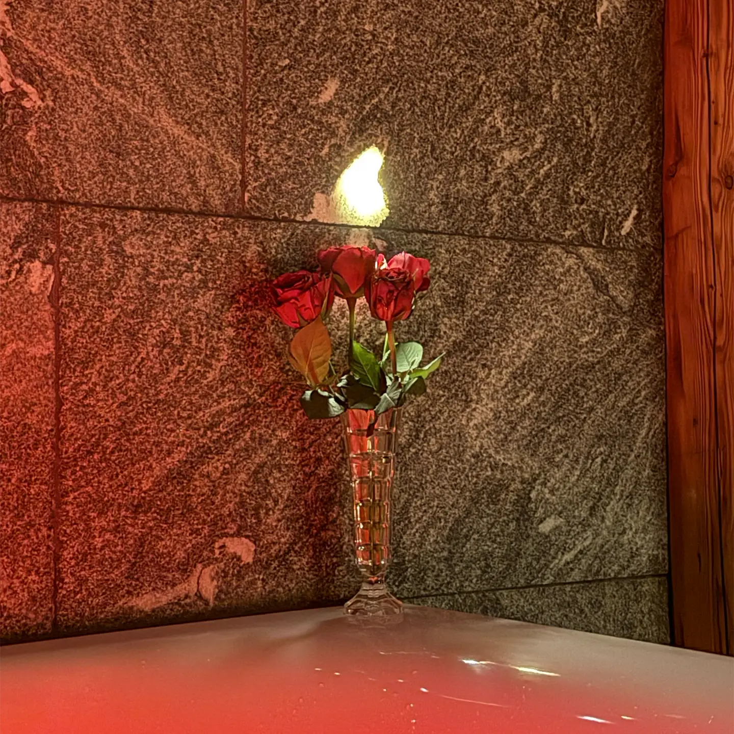 Gemütliche Stimmung in der Wanne mit Rosen auf dem Wannenrand.