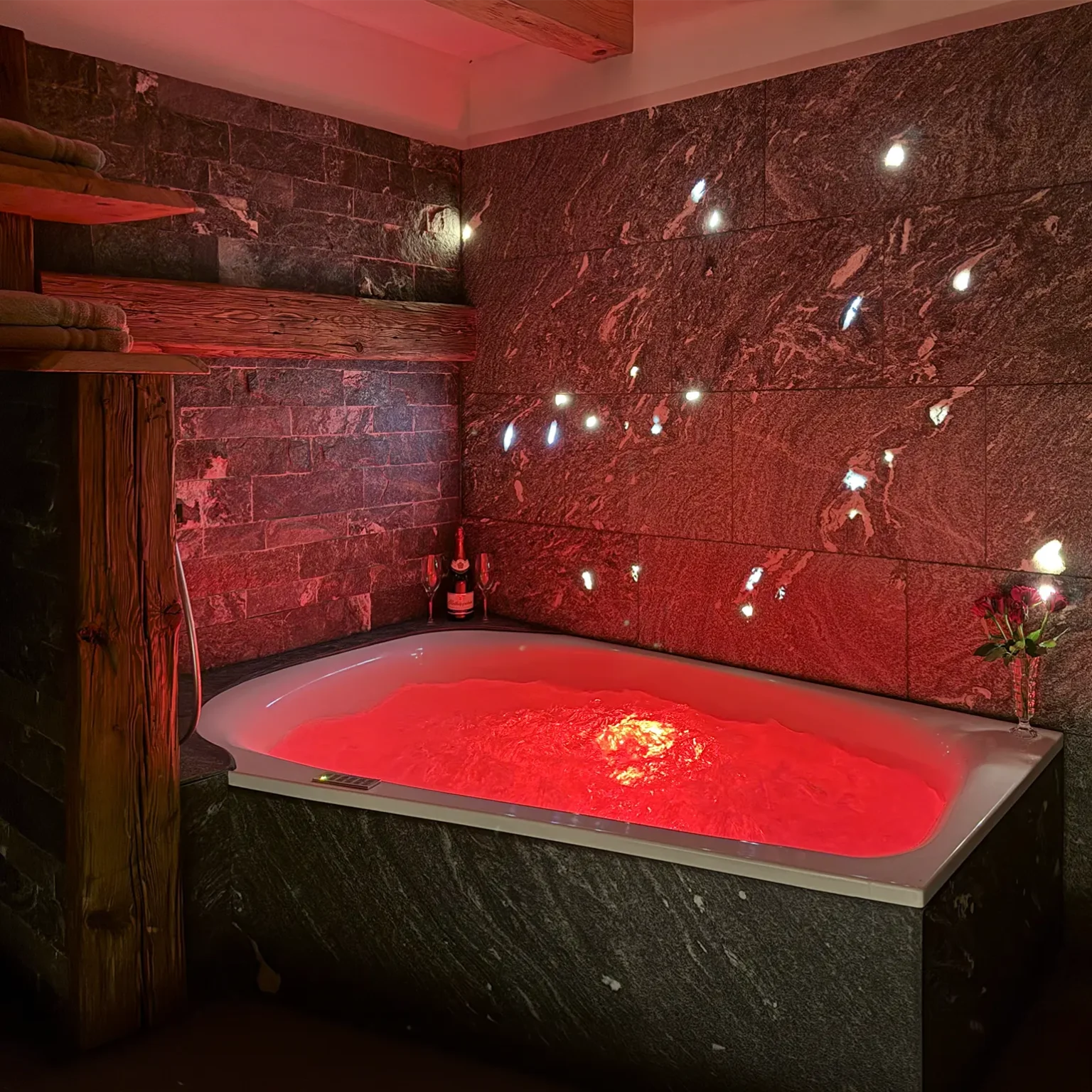 LED-Beleuchtung der Badewanne mit einer Natursteinwand.